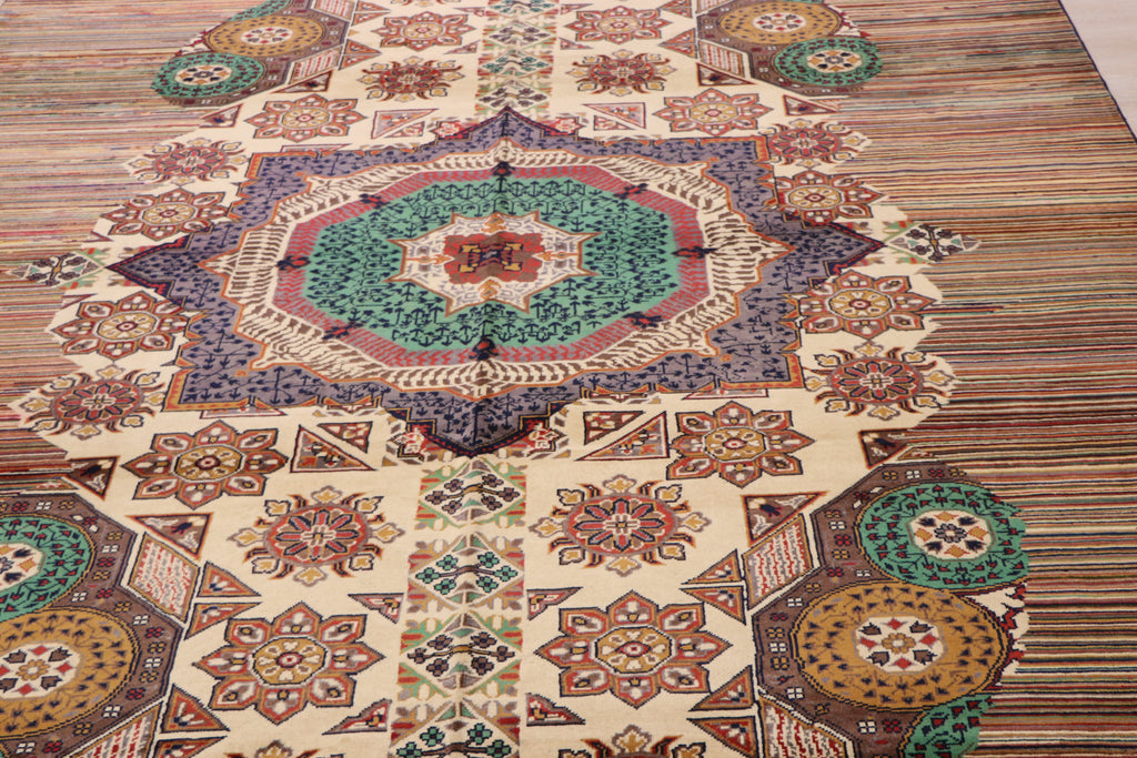A detailed view of a traditional Afghan-style area rug featuring a large central medallion with intricate geometric and floral patterns in beige, teal, brown, and rust tones.
