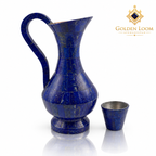 Handmade blue lapis lazuli jug with a curved handle, pedestal base and matching small cup on a white background.
