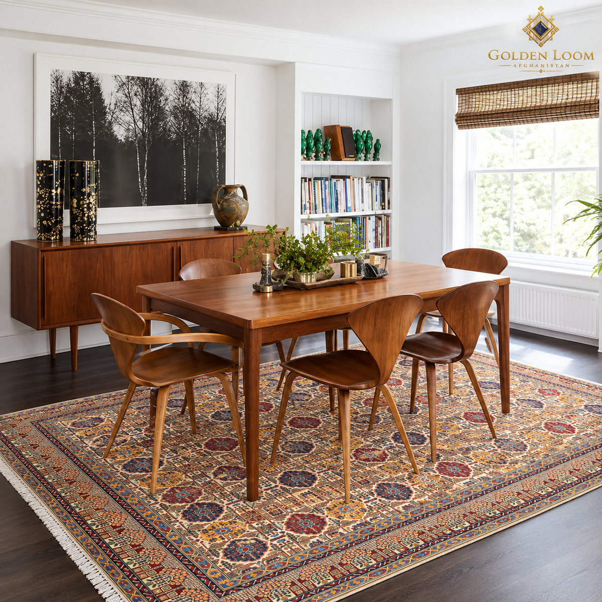 Colorful Afghan area rug styled beneath a wooden dining table and chairs in a bright modern dining room