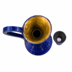 Overhead view of a lapis lazuli jug showing its brass interior, curved stone handle and matching cup alongside.