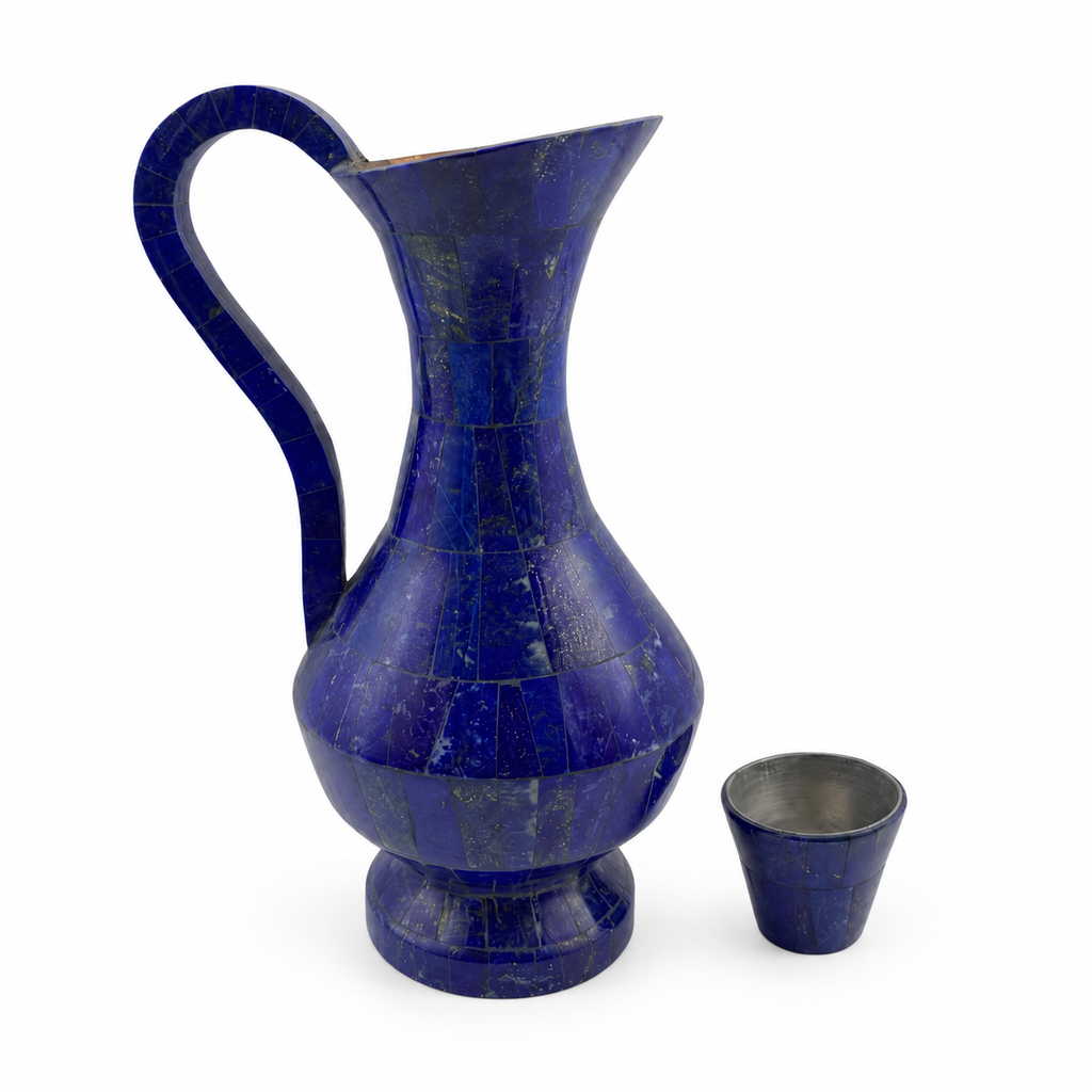 Blue lapis lazuli jug and matching cup displayed on a walnut console beside a window in an ivory interior.