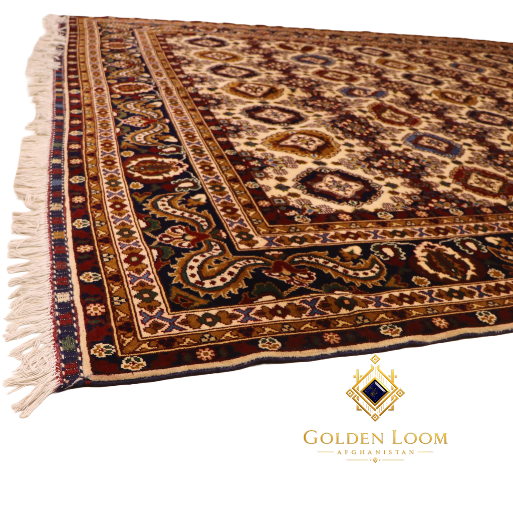 Angled view of large hand-knotted Afghan area rug with all-over geometric medallion field and multi-band paisley border in burgundy and cream