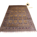 Hand-knotted Afghan carpet in slate grey with gold floral medallion pattern and ivory fringe, angled flat lay