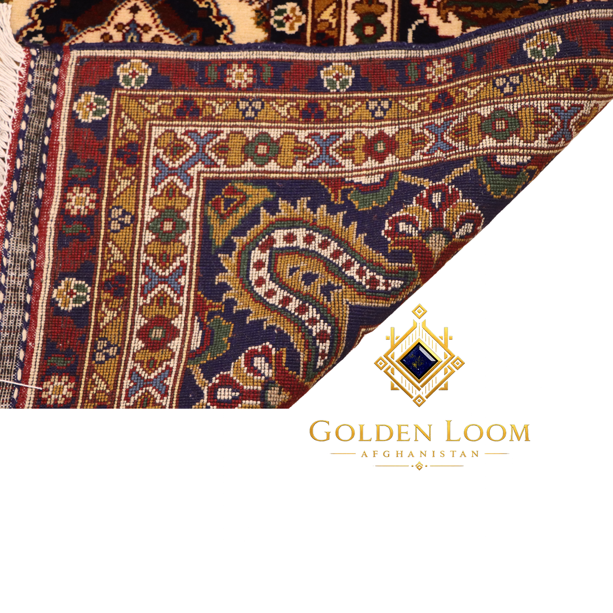 Folded corner of Afghan hand-knotted rug revealing dense wool pile and intricate navy and gold border with floral vine pattern