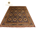 Hand-knotted Afghan area rug with all-over geometric medallion pattern in slate blue and gold, featuring a multi-border frame with crimson guard stripes and ivory fringe