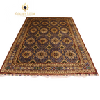 Hand-knotted Afghan area rug with all-over geometric medallion pattern in slate blue and gold, featuring a multi-border frame with crimson guard stripes and ivory fringe