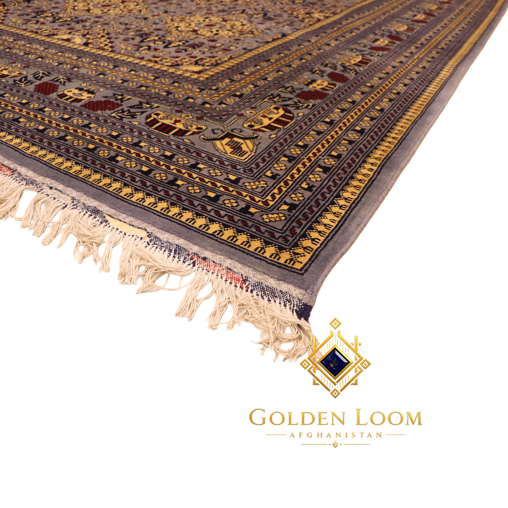 Angled side view of hand-knotted Afghan carpet highlighting multi-layered gold and navy border with ivory knotted fringe on white background