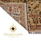 A close-up of a patterned area rug corner with cream, tan, rust, and blue floral motifs and fringe, shown on a white background with the Golden Loom Afghanistan logo below.