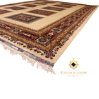 Close-up of hand-knotted Afghan rug corner showing layered geometric border bands in burgundy, gold, and ivory with natural wool fringe