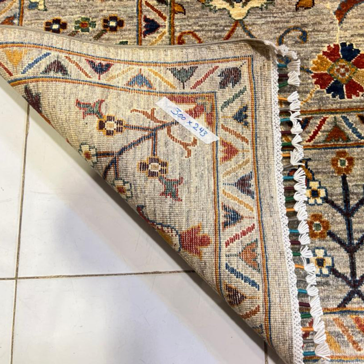 Close-up of the hand-knotted carpet backing, finished edge and white fringe