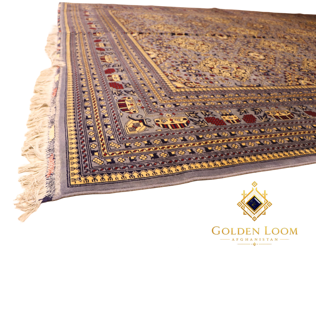 Low-angle perspective of hand-knotted Afghan carpet corner showing layered geometric border in gold, navy, and grey with ivory fringe detail