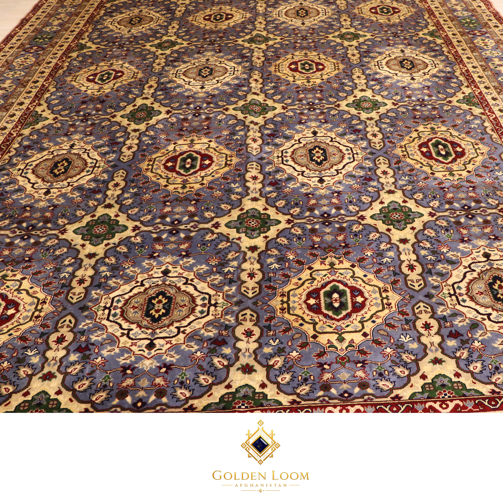 Close-up of the all-over field pattern of a hand-knotted Afghan rug featuring repeating octagonal medallions in ivory on a slate blue ground with red and green floral accents