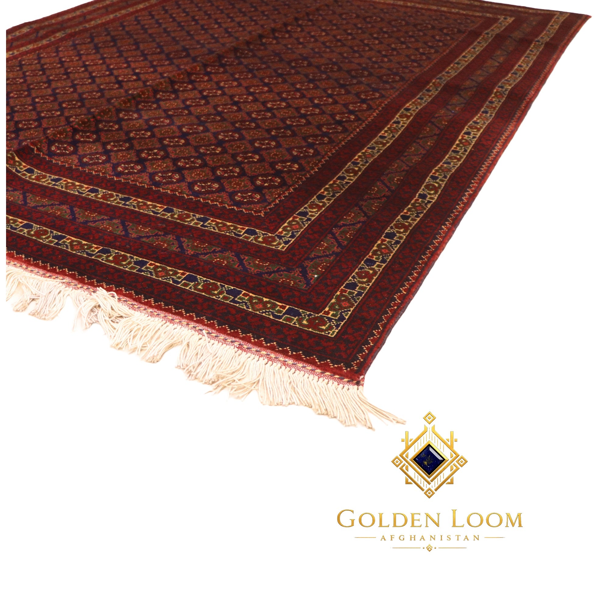 Corner detail of a hand-knotted Afghan wool rug in deep red with repeating diamond medallion motifs and cream fringe — Golden Loom Afghanistan
