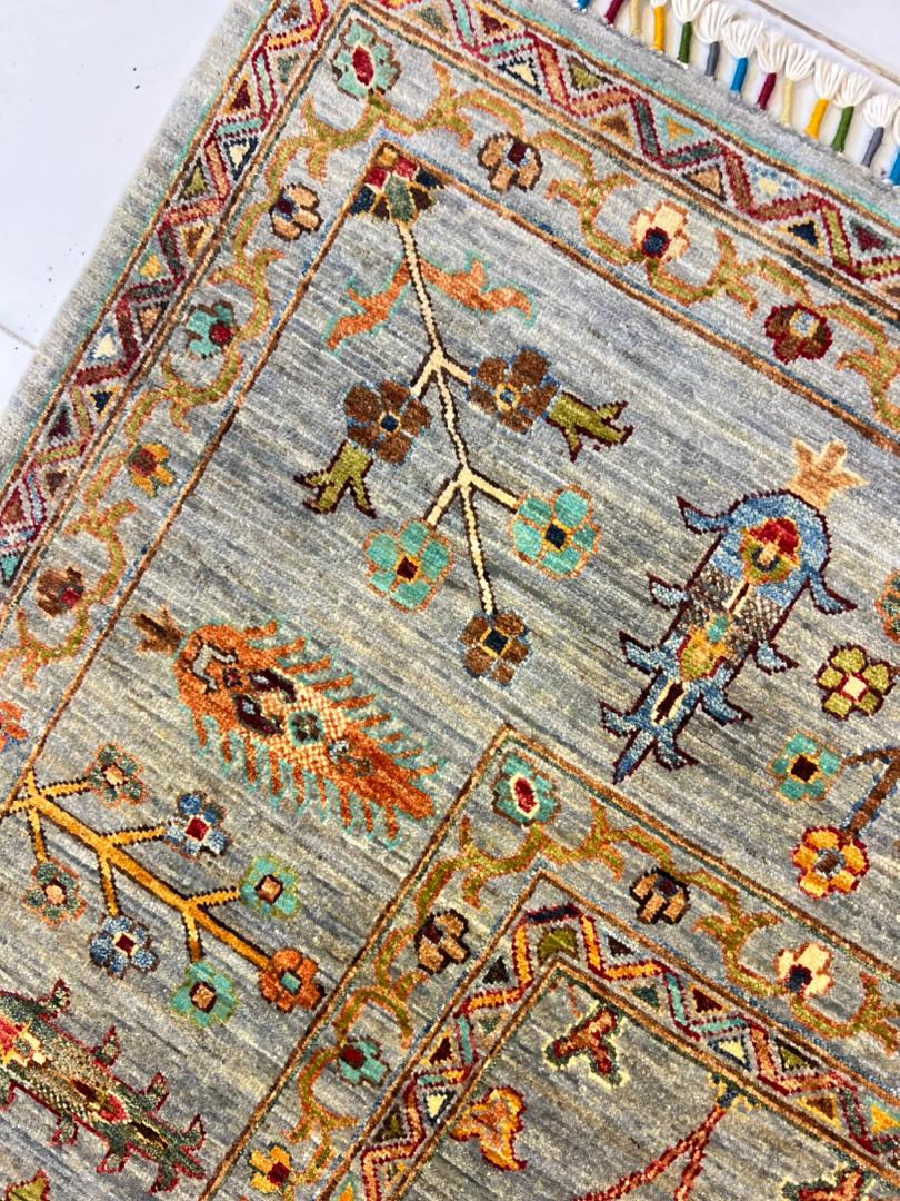 Close-up of Chobi Sultani Diamond carpet pile showing hand-knotted floral and botanical motifs in saffron, teal, crimson and olive on sage grey wool, Jawzjan Afghanistan