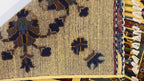 Detail shot of Afghan Chobi rug displaying tribal motifs and burgundy panel borders – 100% natural Turkman wool