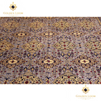 Overhead close-up of hand-knotted Afghan carpet field showing all-over repeating floral and medallion motifs in slate grey, gold, navy, and burgundy