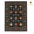 Top view of black hand-knotted Afghan wool carpet with colourful floral motifs, fringed ends and Golden Loom Afghanistan logo