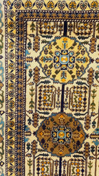 Close-up of Gandumak pattern detail on Belzhiki hand-knotted Afghan carpet – ivory field with geometric medallions in chocolate brown, teal blue and antique gold, floral border with navy and sage green accents, showcasing 40×40 knots per 10cm craftsmanship, Sheberghan Afghanistan